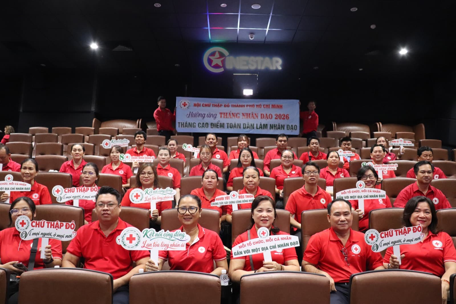 Cán bộ và tình nguyện viên Chữ thập đỏ cầm bảng khẩu hiệu tại lễ hưởng ứng Tháng Nhân đạo 2026