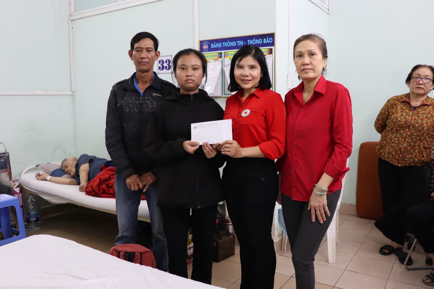 Cán bộ Chữ thập đỏ trao phần hỗ trợ cho thân nhân người bệnh tại khoa điều trị